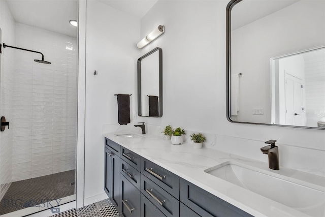 bathroom with tile patterned flooring, vanity, and tiled shower