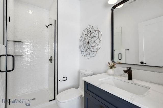 bathroom with a shower with door, vanity, and toilet