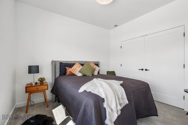 bedroom featuring light carpet and a closet