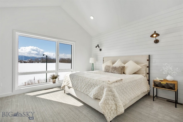 bedroom featuring wooden walls, high vaulted ceiling, and light colored carpet