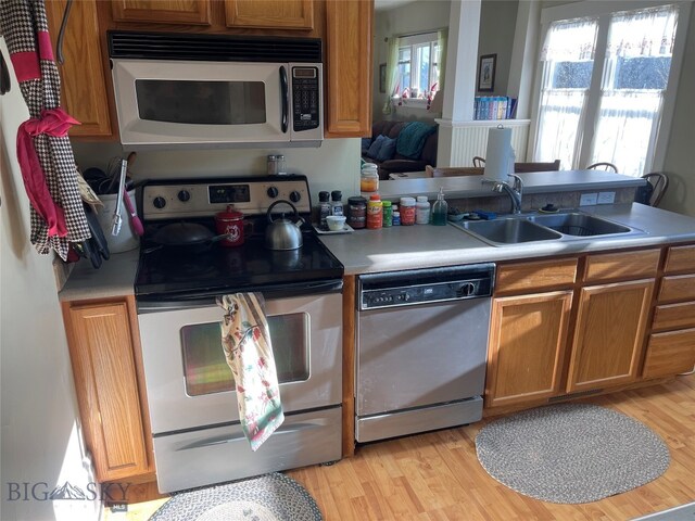 kitchen featuring appliances with stainless steel finishes, light hardwood / wood-style flooring, and sink