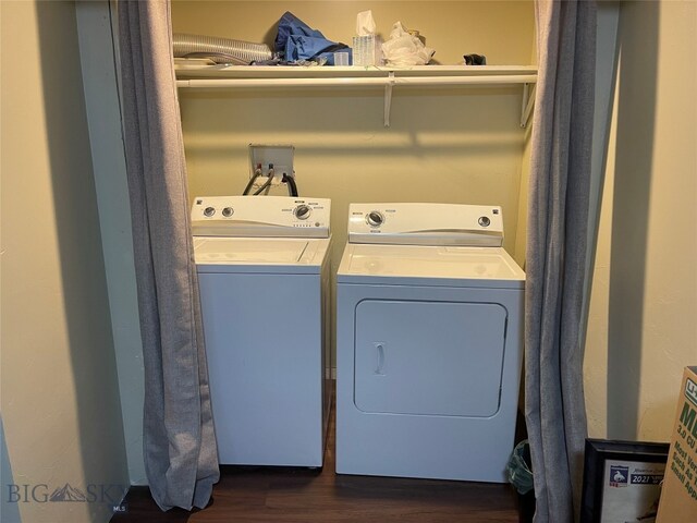 clothes washing area with washing machine and clothes dryer and dark hardwood / wood-style flooring