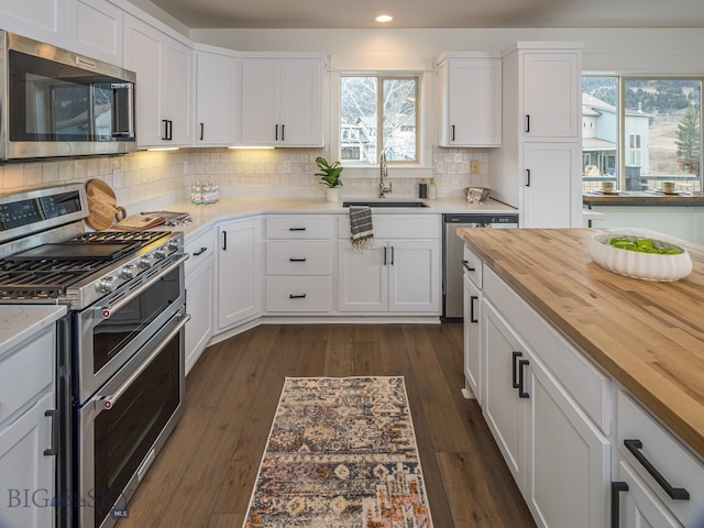 kitchen with white cabinetry, sink, dark hardwood / wood-style floors, and appliances with stainless steel finishes