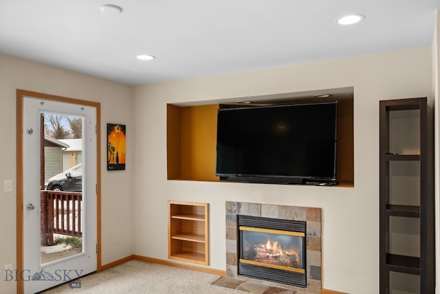 unfurnished living room featuring light carpet, built in features, recessed lighting, and a tiled fireplace