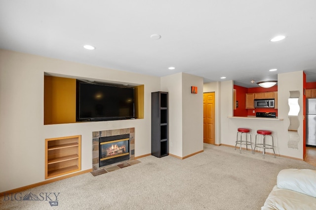 carpeted living room with built in shelves and a tile fireplace