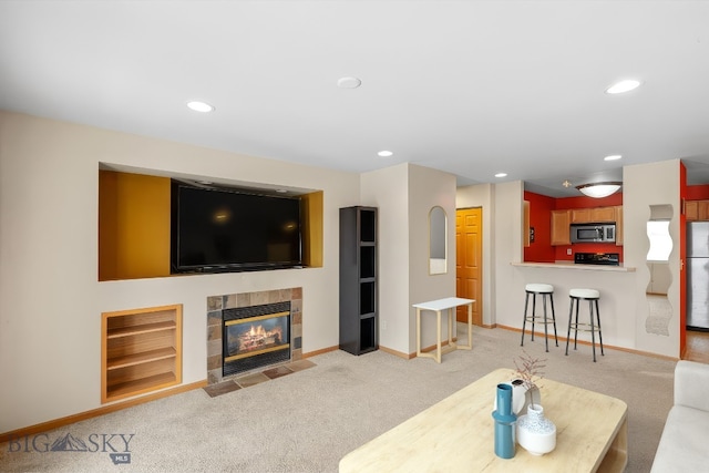 living area with a tiled fireplace, recessed lighting, baseboards, and carpet floors