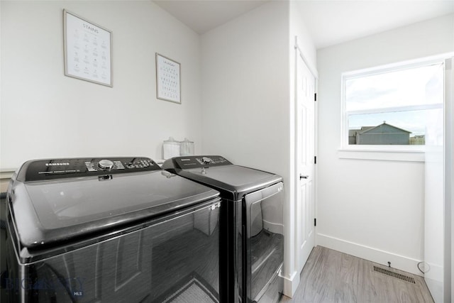 washroom featuring separate washer and dryer and light wood-type flooring