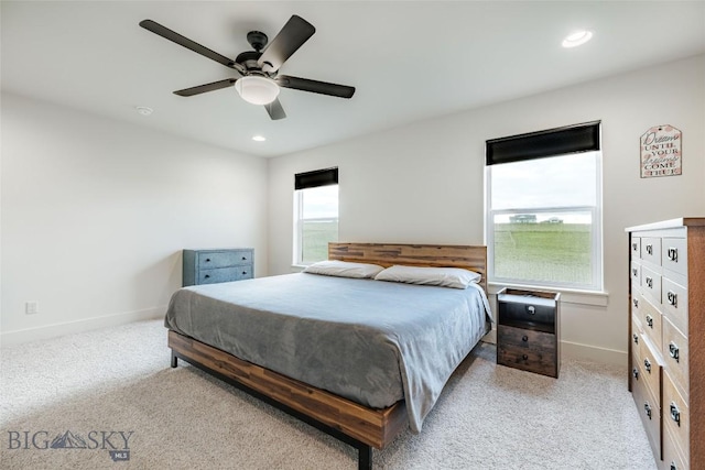 carpeted bedroom featuring ceiling fan and multiple windows