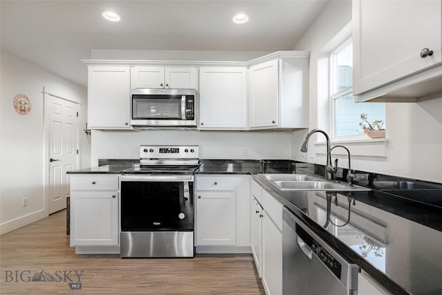 kitchen featuring white cabinets, stainless steel appliances, light hardwood / wood-style floors, and sink