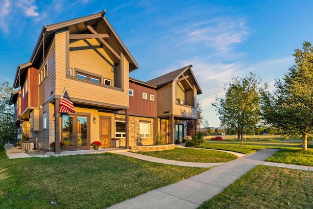 rear view of property featuring french doors and a lawn