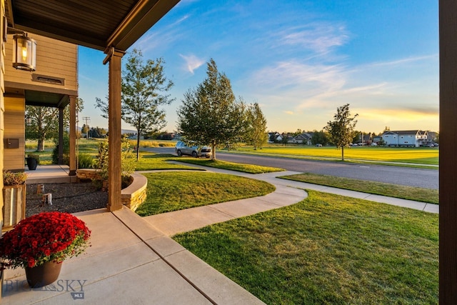 yard at dusk featuring a porch