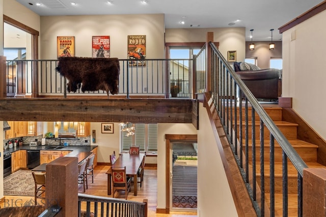 stairway with a chandelier, hardwood / wood-style flooring, and sink