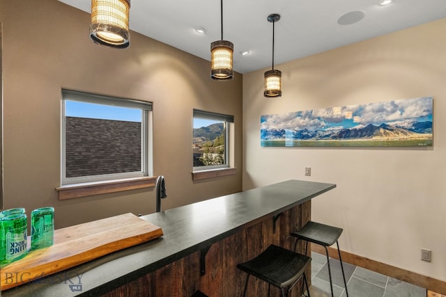 bar featuring light tile patterned floors and pendant lighting