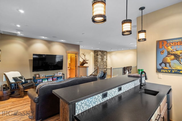 interior space featuring sink, decorative light fixtures, and hardwood / wood-style flooring