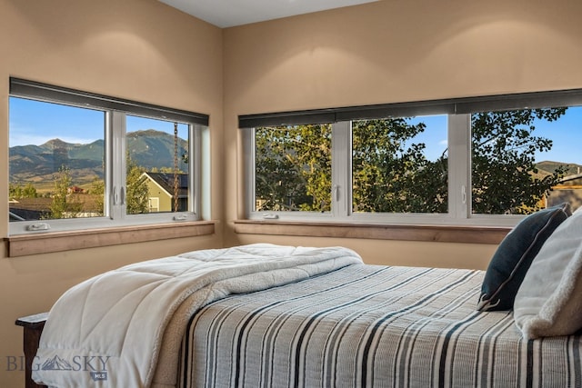 bedroom with a mountain view and multiple windows