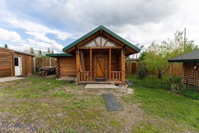 back of property with a lawn and an outdoor structure