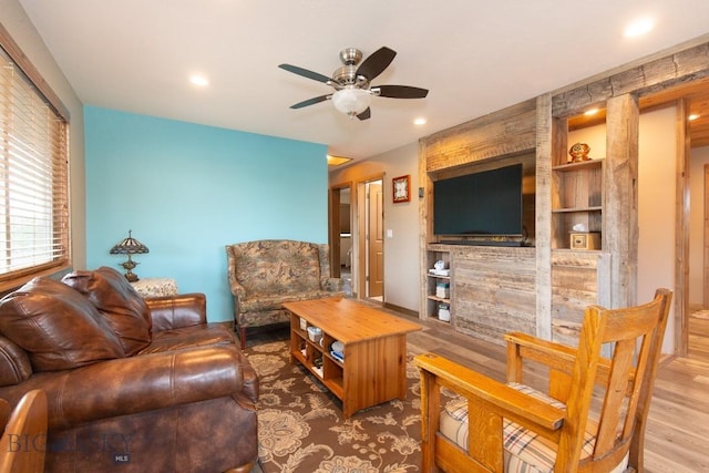 living room with hardwood / wood-style floors, ceiling fan, and built in features