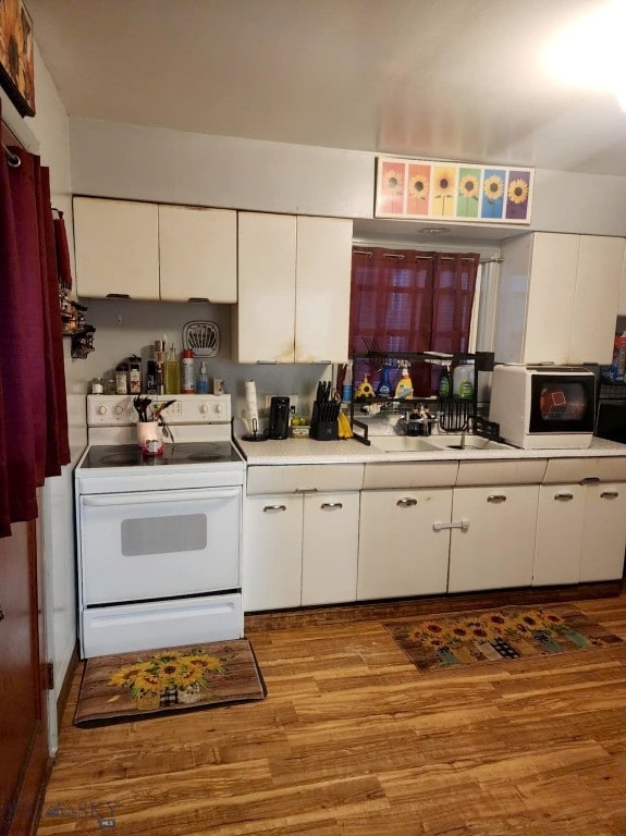 kitchen featuring white cabinets, white appliances, sink, and light hardwood / wood-style flooring