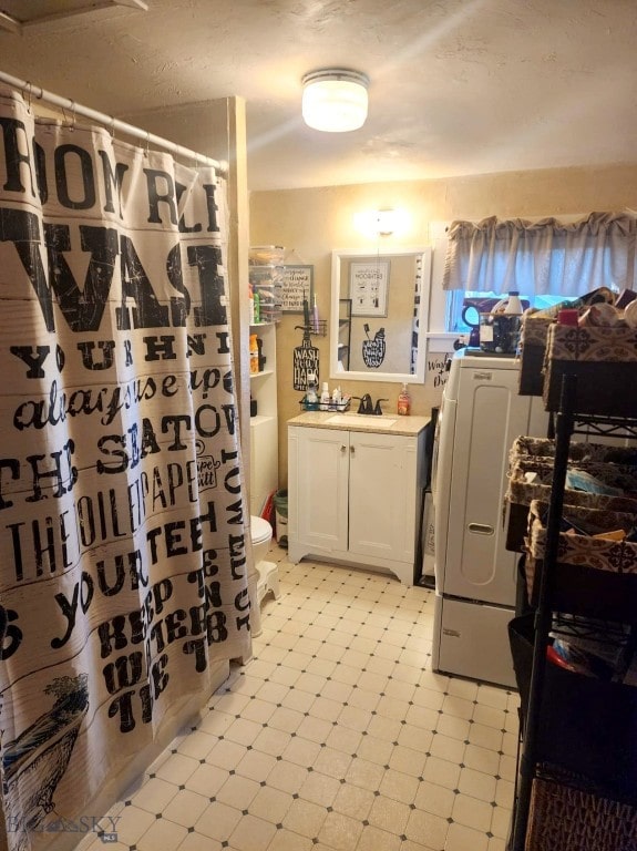 bathroom with washer / dryer, vanity, and toilet