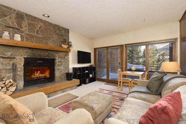 carpeted living room with a textured ceiling and a stone fireplace