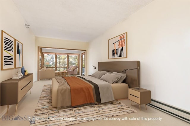 bedroom featuring light colored carpet and a baseboard heating unit