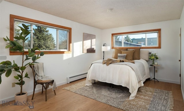 bedroom featuring a baseboard radiator, a textured ceiling, and hardwood / wood-style flooring