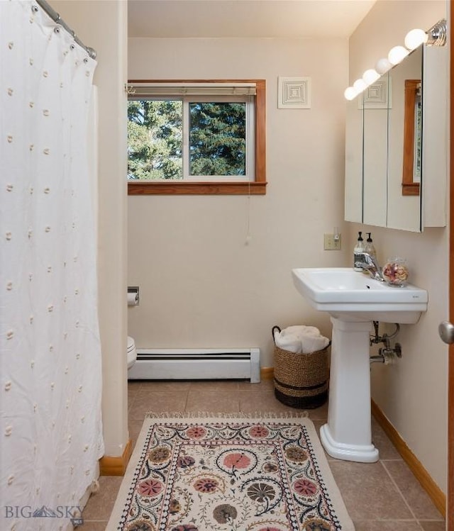 bathroom featuring tile patterned flooring, toilet, and a baseboard radiator