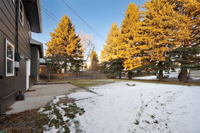 yard layered in snow with a patio area