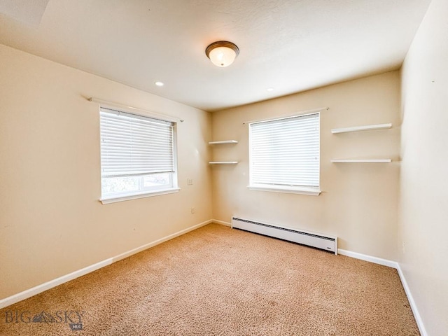 carpeted empty room featuring a baseboard heating unit