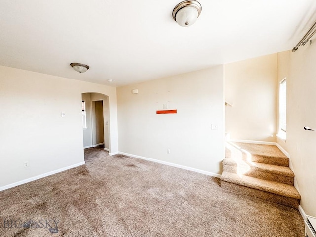 carpeted spare room with a baseboard radiator