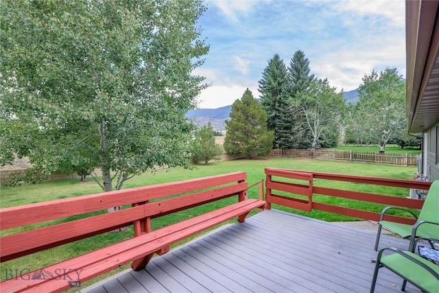 wooden terrace with a mountain view and a yard