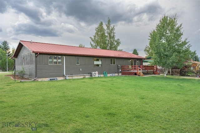 rear view of house featuring a deck and a yard