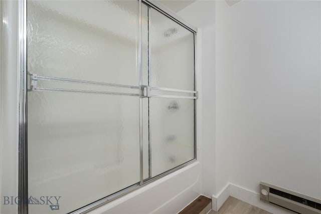 bathroom with combined bath / shower with glass door and wood-type flooring