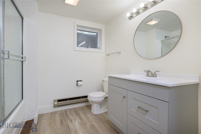 full bathroom with a baseboard heating unit, hardwood / wood-style floors, bath / shower combo with glass door, toilet, and vanity