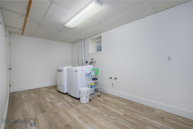 laundry area with washer and dryer and light hardwood / wood-style floors