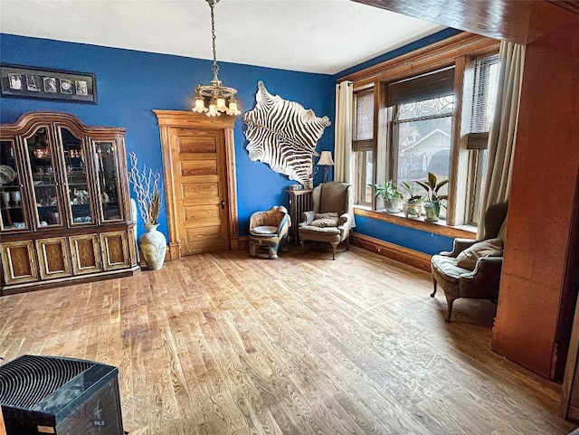 sitting room featuring a chandelier and wood-type flooring