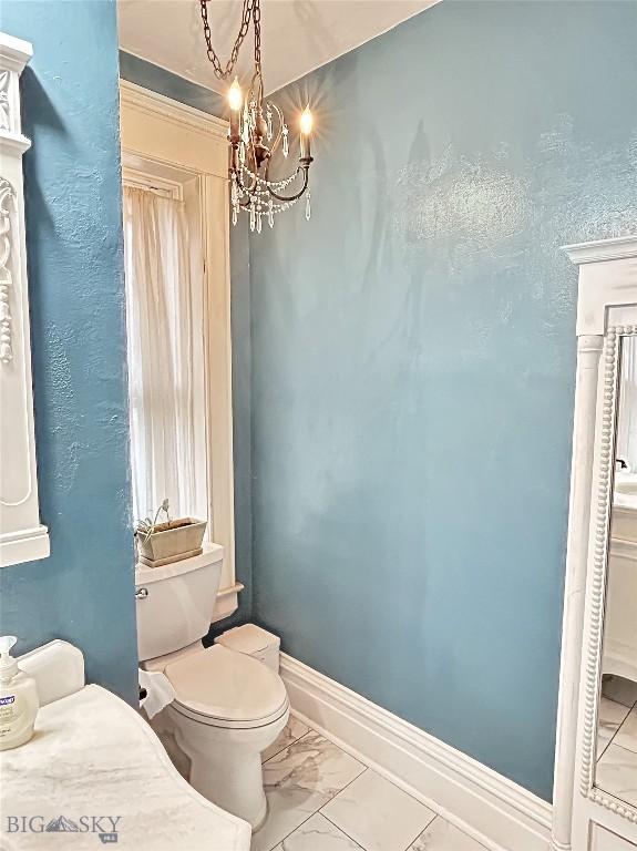 bathroom featuring toilet and a chandelier