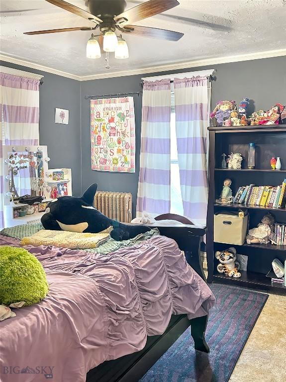 carpeted bedroom with a textured ceiling, radiator, crown molding, and ceiling fan