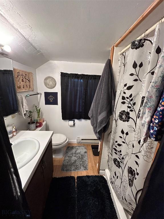 bathroom with vanity, toilet, wood-type flooring, and a baseboard heating unit