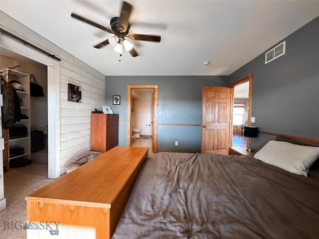 bedroom featuring ensuite bath, ceiling fan, a closet, and light carpet