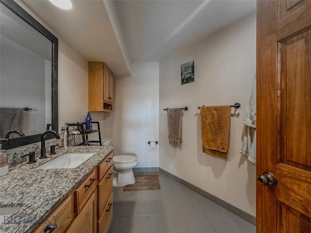 bathroom featuring tile patterned flooring, vanity, and toilet