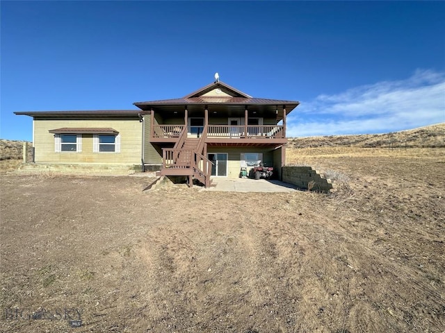 rear view of property with a deck and a patio