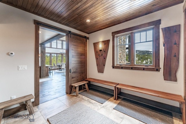 interior space featuring light tile patterned floors, a barn door, and wood ceiling