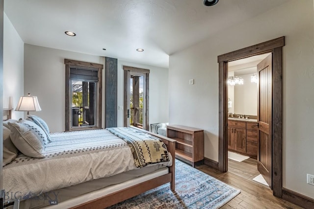 bedroom featuring access to outside, connected bathroom, light hardwood / wood-style floors, and sink