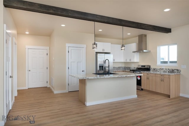 kitchen with wall chimney exhaust hood, a kitchen island with sink, beam ceiling, stainless steel appliances, and a sink