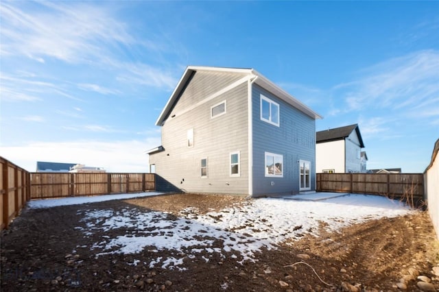 snow covered property with a fenced backyard and a patio