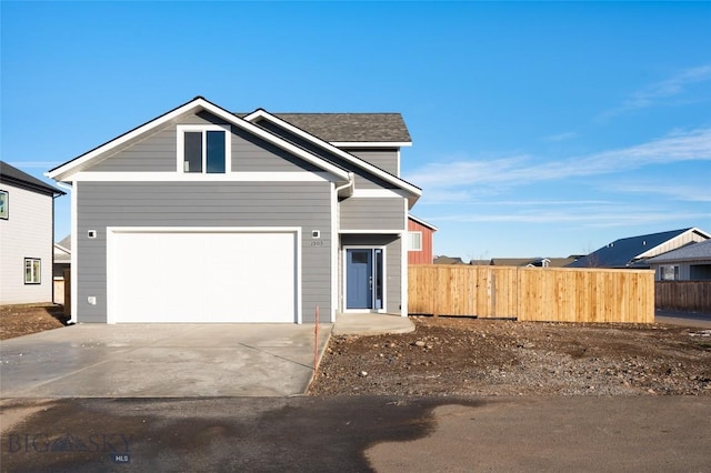 view of front of home featuring a garage, concrete driveway, and fence