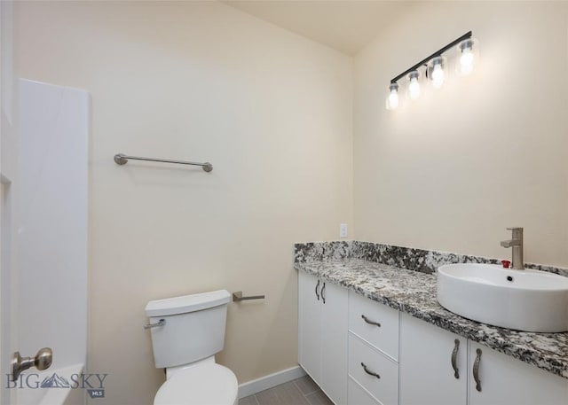 bathroom with toilet, baseboards, and vanity