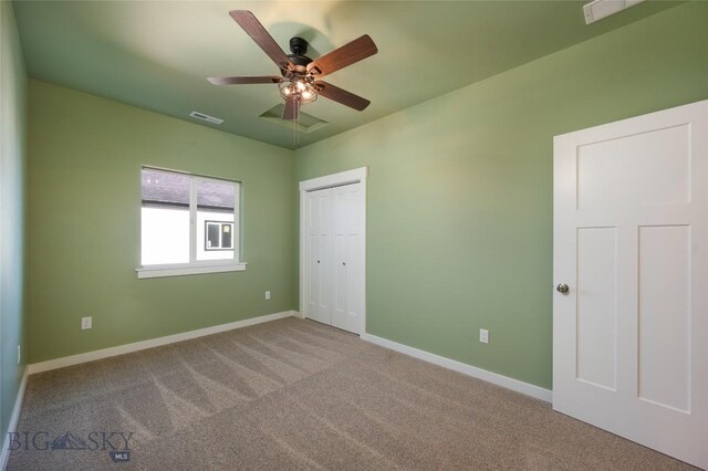 unfurnished bedroom with a closet, carpet flooring, visible vents, and baseboards