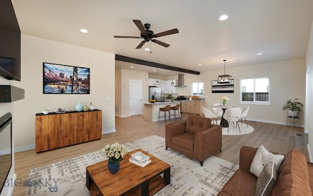 living room with baseboards, light wood finished floors, and recessed lighting